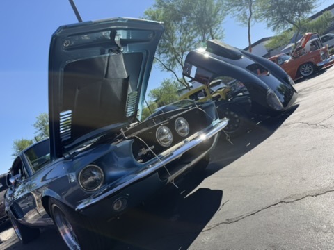 Factory Five Daytona replica with classic cars and hoods open