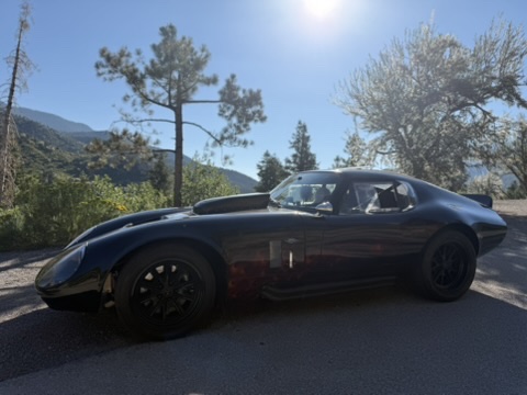 Side profile of the Factory Five Daytona replica in mountain sunlight