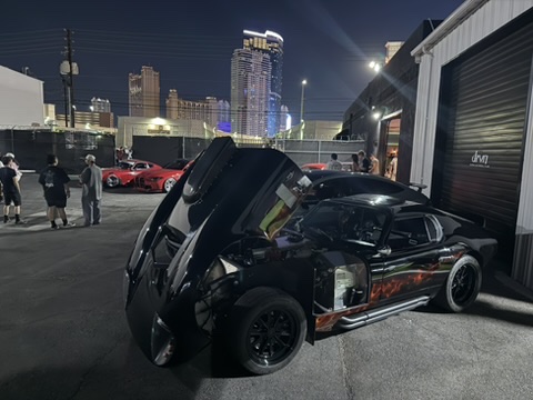 Factory Five Daytona replica with hood open at a nighttime Las Vegas meet